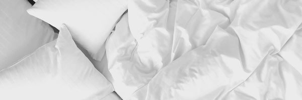 Crumpled clean white sheets and white pillows after waking up 